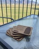 coasters stacked on a glass tabletop with a view of the mountains behind a railing